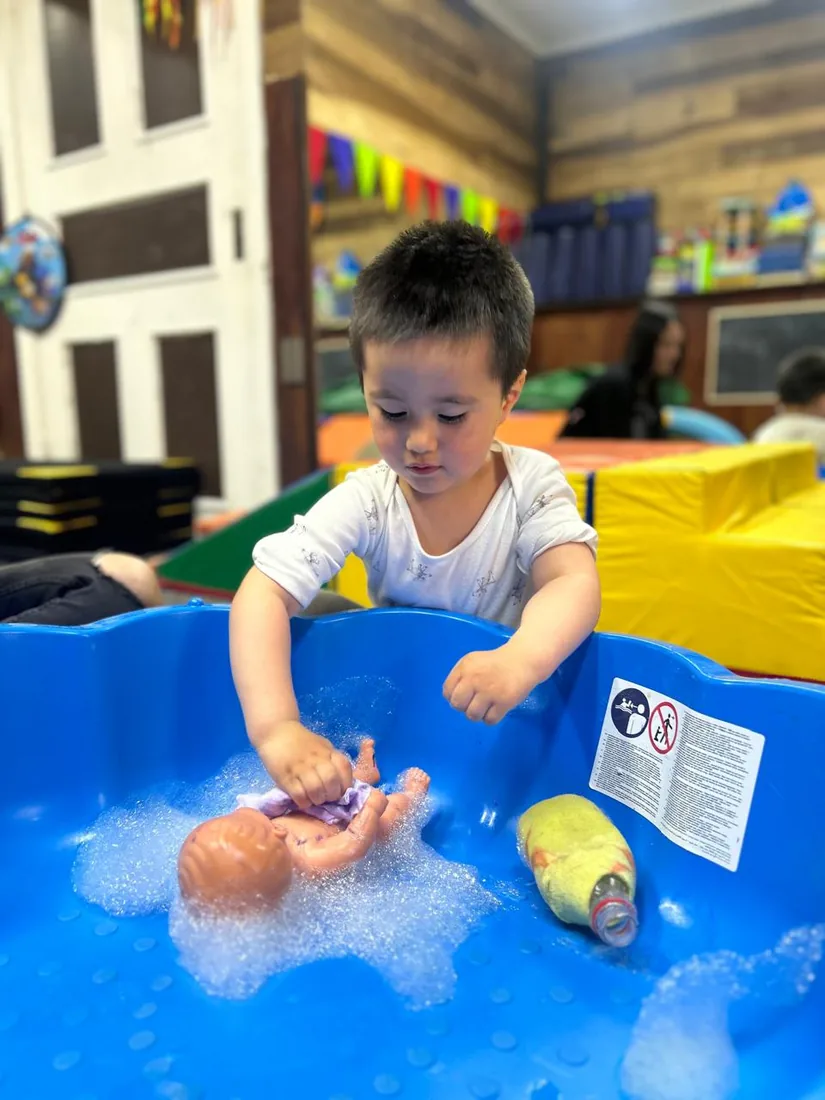 Niño participando en una actividad de exploración con agua y espuma en INFANCIACTIVA