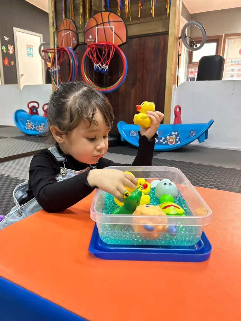 Niña explorando materiales sensoriales en INFANCIACTIVA
